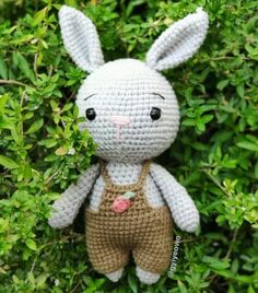 a crocheted bunny is sitting in the bushes