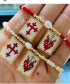 three pieces of cross beaded bracelets in gold, red and white beads with pearls