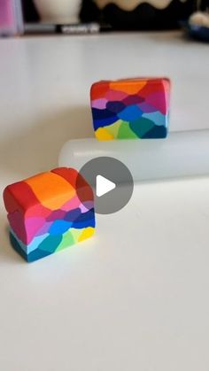 two pieces of colorful candy sitting on top of a white counter next to each other