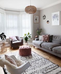 a living room with couches, chairs and rugs on the wooden flooring