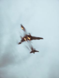 two airplanes flying in the sky on a cloudy day