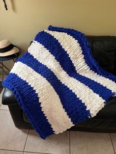 a blue and white blanket sitting on top of a black couch