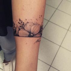 a woman's arm with a tattoo on it that has an image of a baseball glove and flowers