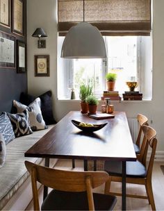 a wooden table sitting under a window in a living room