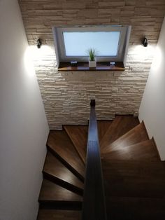 an overhead view of a stair case with a skylight above it and wood flooring