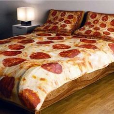 a bed with a pizza comforter on top of it in a bedroom next to a lamp