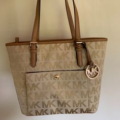 Brand New Michael Kors Monogram Tote Bag With Tags Attached! Super Cute Tan Color With Big Zipper Inside. Looks Similar To The Bag On The Model But A Different Color. This Bag Is A Go-To With Any Outfit! Message Me To Negotiate Price! Will Negotiate So Message Me!! Beige Logo Tote Shoulder Bag, Beige Double Handle Bag With Logo, Cream Tote Shoulder Bag With Logo, Cream Logo Tote Shoulder Bag, Beige Shoulder Bag With Logo For Shopping, Beige Logo Shoulder Bag For Shopping, Tan Monogram Canvas Bag With Logo, Tan Monogram Canvas Bags With Logo, Cream Logo Bag For Daily Use