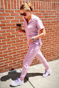 Female medical professional walking and holding a cup of coffee Scrub Outfits, Nursing 101, Dream Career