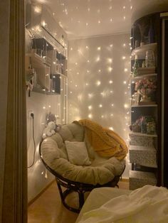 a room that has some lights on the wall and a chair in it with pillows