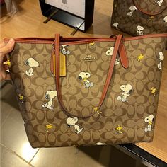 Coach X Peanuts City Tote In Signature Canvas With Snoopy Woodstock Print (Coach Cf166) Gold/Khaki/Redwood Multi Coach Style # Cf166 | Signature Coated Canvas And Smooth Leather | Inside Zip Pocket | Snap Closure | Handles With 10" Drop | 13" (L) X 11 1/2" (H) X 6 1/4" (W) | This Special Coach X Peanuts Collaboration Combines Our Legacy Of Leathercraft With The Playful Attitude Of The Peanuts Crew | 2022 Peanuts Worldwide|Style No. Cf166| Snoopy Purse, Snoopy Things, Snoopy Items, Paw Wallpaper, Snoopy Stuff, Money Bags, Snoopy Woodstock, The Peanuts, Pinterest Ideas