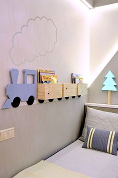 a child's room with a bed, book shelf and toy train on the wall