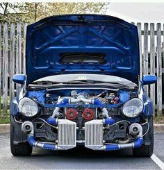 the front end of a blue car with its hood open