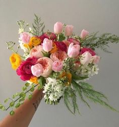 a person holding a bouquet of flowers in their hand