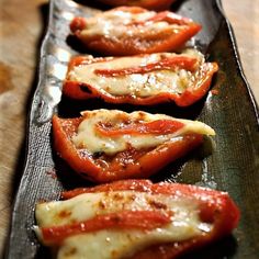 several slices of tomato on a black plate