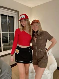 two women standing next to each other in front of a white couch wearing matching outfits