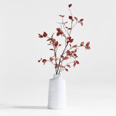 a white vase with red flowers in it