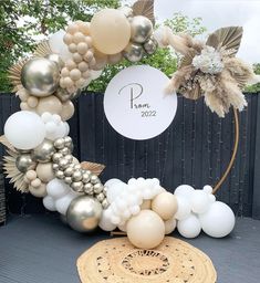 a balloon arch with white and gold balloons