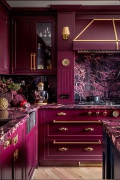 a kitchen with purple cabinets and marble counter tops, gold trimmings on the backsplash