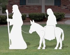 a paper cut out of a man and woman on a horse in front of a house