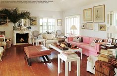 a living room filled with furniture and a fire place in the middle of a wooden floor