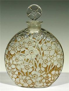 a white and gold glass vase with flowers on it