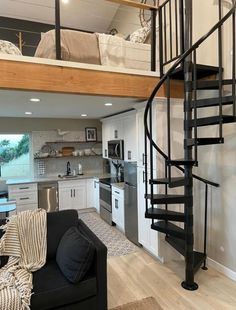 a living room with a spiral staircase next to a kitchen