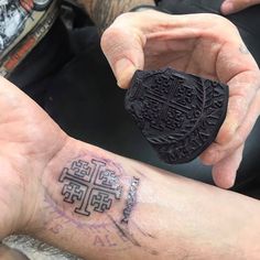 a man with a tattoo on his arm holding up a piece of black ink that reads,