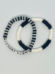 Cheer on your Penn State Nittany Lions with this Heishi bead bracelet.  Created with white square beads that spell the words, Nittany Lions. Stretch bracelet measures about 7.25" Also available: https://pennypiejewelry.etsy.com/listing/1528024495 NOTE: The best way to keep a stretch bracelet in good shape is to roll the bracelet on and off your hand and wrist. Continuously pulling it wider to put on your wrist will lead to overstretching and possibly breakage.  NOTE: Silver beads may tarnish with prolonged exposure to lotions or perfumes. Not recommended to wear in salt or chlorine water. Other college teams available. White Stacked Beaded Bracelets As Gift, White Stacked Stretch Bracelet As Gift, White Rectangular Bracelets For Gift, Adjustable White Stacked Beaded Bracelets, Adjustable Stacked White Beaded Bracelets, White Stacked Stretch Bracelet Gift, White Stacked Stretch Bracelet With Round Beads, Personalized White Heishi Beads Bracelet, White Name Bracelet With Letter Beads And Heishi Beads