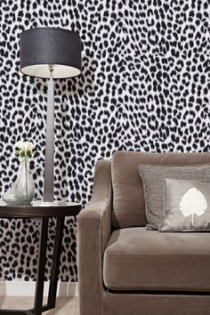 a leopard print wallpaper in a living room with a couch and lamp next to it