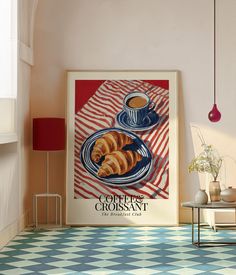 there is a coffee and croissant poster on the wall next to a table