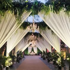 an outdoor wedding venue with white drapes and chandelier