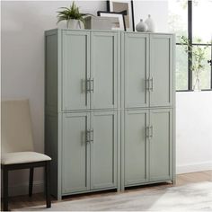 a large green cabinet sitting in the corner of a room next to a white chair