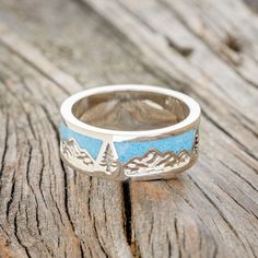 a silver and blue ring with mountains on it