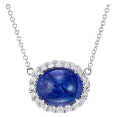 Vivid blue earth mined tanzanite and diamond pendant necklace. 8.00 carat oval cabochon center stone with blue and purple overtones surrounded a brilliant cut diamond halo. 18 inch 18k white gold chain. Created in the Peter Suchy Workshop 1 oval cabochon blue tanzanite, MI approx. 8.00cts 20 round brilliant cut diamonds, F-G VS, approx. .40cts 18k white gold Stamped: 18k 750 5.9 grams Top to bottom: 13.2mm or .5 Inch Width: 15.8mm or 5/8 Inch Depth or thickness: 9.8mm Chain: 18 Inches Total leng Round Pendant Necklace 1stdibs, Oval Diamond Cabochons For Formal Occasions, Fine Jewelry Cabochon Gemstones For Formal Occasions, Formal Fine Jewelry Cabochon Gemstones, Formal Fine Jewelry Gemstone Cabochons, Formal Round Gemstone Cabochons, Formal Cabochon Round Gemstone, White Gold Gemstone Cabochons Fine Jewelry, Oval Sapphire Necklace With Brilliant Cut