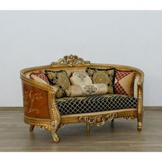 an ornately decorated couch sitting on top of a hard wood floor next to a white wall