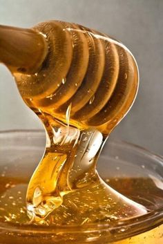 honey being poured into a glass bowl