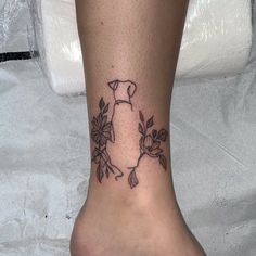 a woman's foot with a small tattoo on the side of her leg,