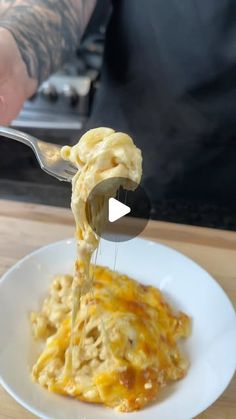 a person is holding a spoon with some food in it on a white plate,