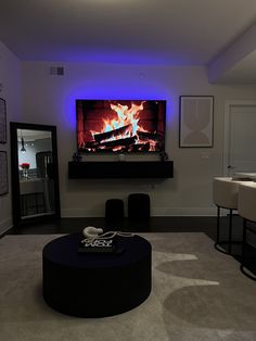 a living room with a large television and fireplace