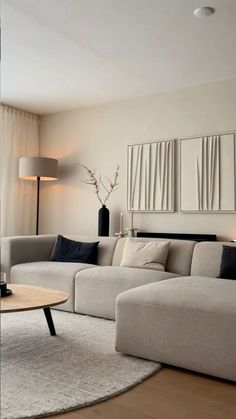 a living room filled with furniture next to a large white couch and table on top of a hard wood floor