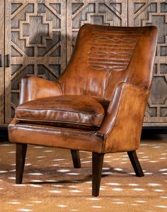 a brown leather chair sitting on top of a rug