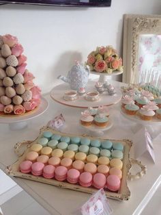 a table topped with lots of cupcakes and cakes