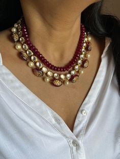 The First Layer is made of Maroon beads, the Second Layer is Round Kundan Stones and the Third Layer is Glass Stones with intricate Red and Green Meenakari work. This multi-faceted necklace can add to any contemporary fashion look. Traditional Pearl Necklace With Faceted Beads For Festivals, Traditional Faceted Beads Pearl Necklace For Festivals, Traditional Pearl Necklace With Faceted Beads For Festive Occasions, Traditional Festive Pearl Necklace With Faceted Beads, Multicolor Necklaces With Stone Work And Round Beads, Temple Jewelry Necklaces With Gemstone Beads For Celebrations, Beaded Necklaces With Stone Work For Gift, Elegant Kundan Necklace With Gemstone Beads, Wedding Diwali Necklaces With Faceted Beads