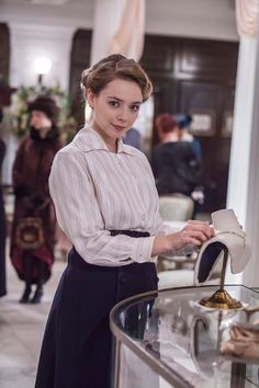 a woman standing in front of a glass display case