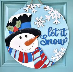 a blue door with a snowman and let it snow sign hanging from the front