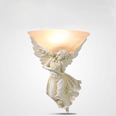 a white angel holding a light bulb on top of it's head and body