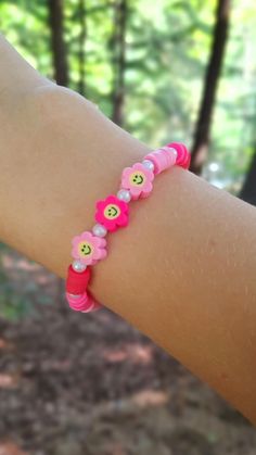 This super cute clay bead bracelet is made with high quality beads. It has a pattern of dark pink, pink, and then light pink all separated by pearls. There are 3 smiley face flowers in the center. you can find a similar design but with a randomized pattern in my etsy store. Please note that colors and pattern may vary from each bracelet. All bracelets vary from 6.5 inches to 6.75 inches.  While the string I use is high quality, be careful not to overstretch the bracelet as it will shorten its lifespan. In addition, keep out of water as it will shorten the lifespan of the bracelet. Excessive sweating and water exposure may also rust any gold beads if there are any gold beads on the bracelet.  WARNING: keep out of reach of children as this product is a choking hazard. Pink Fun Bracelets With Round Beads, Pink Round Beads Kawaii Jewelry, Fun Pink Beaded Bracelets With Round Beads, Pink Round Beads Bracelets, Fun Style, Fun Pink Bracelets With Round Beads, Fun Pink Beaded Bracelets, Playful Pink Beaded Bracelets, Pink Kawaii Jewelry With Colorful Beads, Fun Pink Jewelry With Letter Beads