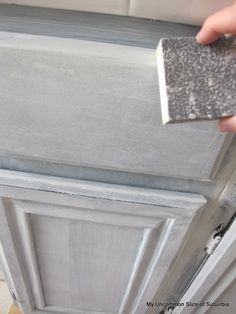 a person is painting the side of a door with gray paint and silver flakes