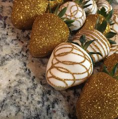 chocolate covered strawberries are lined up on a counter top with gold glittered decorations