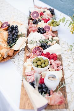 two wooden trays filled with different types of cheese and fruit on top of a table